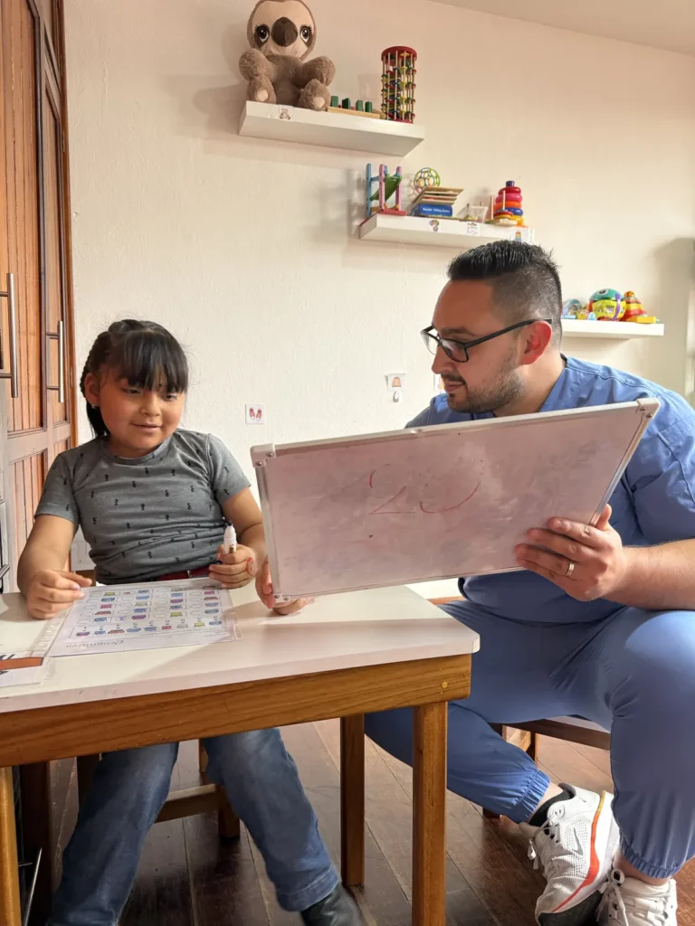 Especialista de CALMA realizando una evaluación del neurodesarrollo con una niña en Cuenca