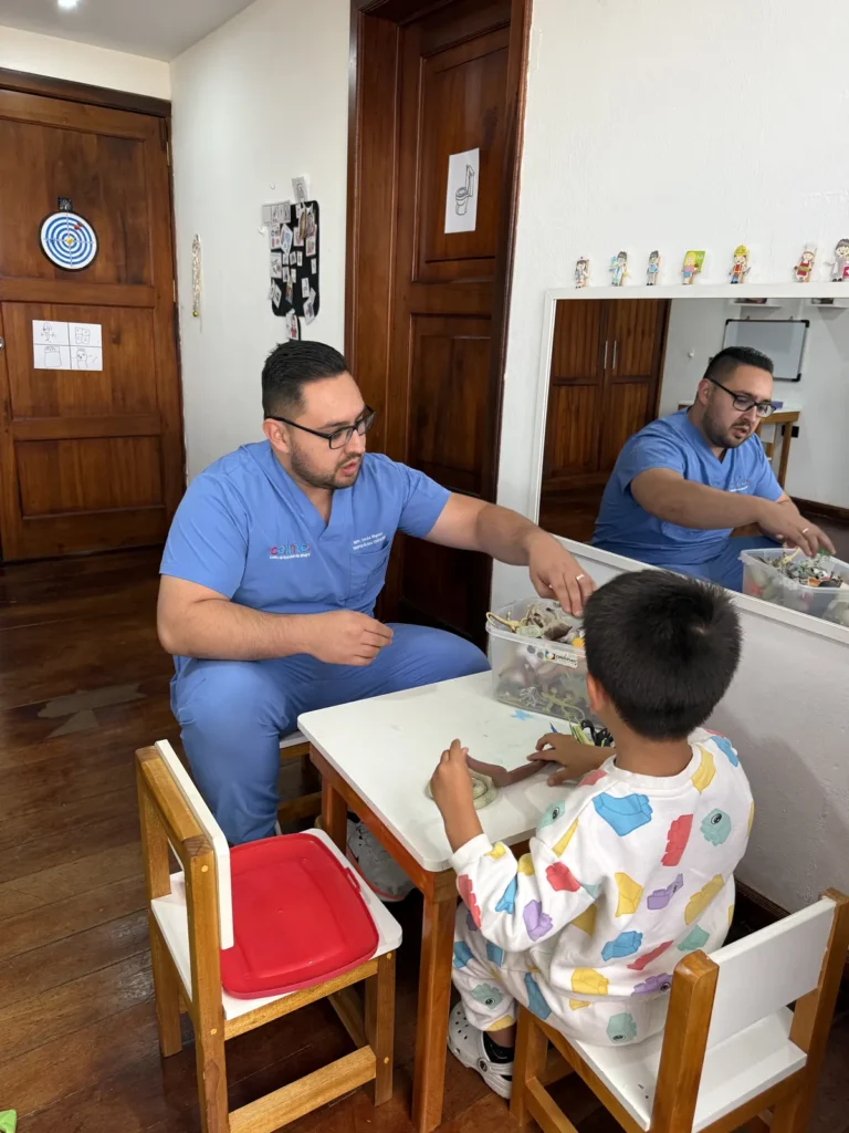Neuropsicólogo de CALMA evaluando funciones cognitivas de un niño en mesa de trabajo