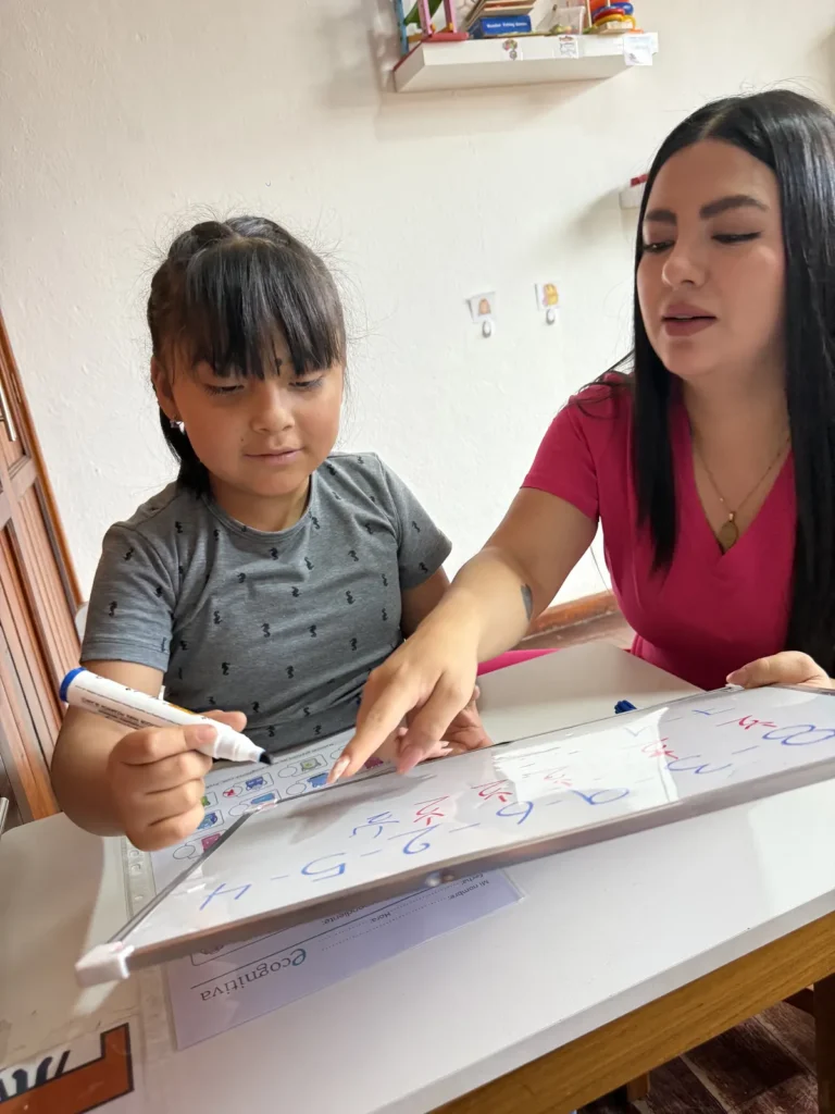 Samantha Mogrovejo acompañando a una niña durante una sesión de terapia de lenguaje en Cuenca